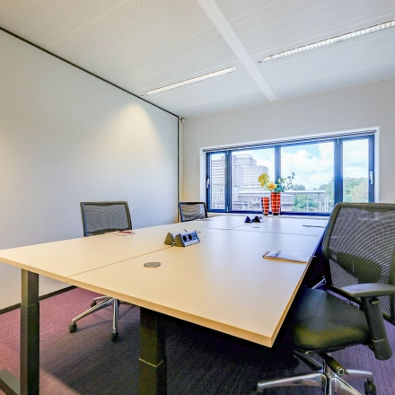 Bright office space with desks and chairs, featuring a window view at Prins Bernhardplein 200, Amsterdam Amstel. Ideal for office space rental.