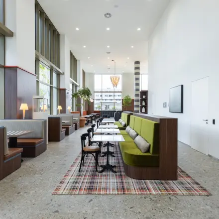 Modern office space with stylish booths and tables, featuring large windows and a minimalist design at Willem Fenengastraat 16, Amsterdam Amstel. Ideal for office space rental.