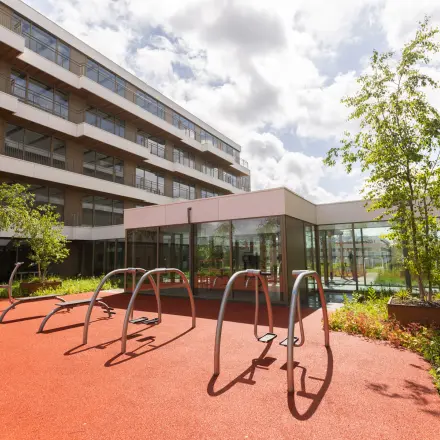 Exterior of office building at Willem Fenengastraat 16, Amsterdam Amstel, showcasing a bike rack on a sunny day with modern office space rental opportunities.
