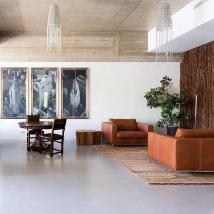Spacious and modern lounge area in an Amsterdam Buitenveldert office to rent at Teilingen 1, featuring contemporary leather seating, artistic wall decor, and ambient lighting, ideal for relaxation or informal meetings.