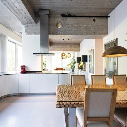 Bright and modern workspace featuring a sleek kitchen setup with wooden dining table, stylish lighting, and large windows at Teilingen 1, Amsterdam Buitenveldert, ideal for office space rental.