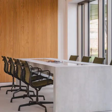 Stylish conference room available for office space rental at Walborg 2A, Amsterdam Buitenveldert, featuring a sleek table and comfortable chairs against a modern wooden accent wall.