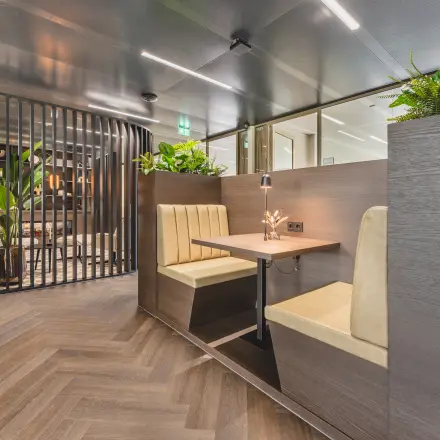 Modern office space with wooden furniture and greenery at Walborg 2A, Amsterdam Buitenveldert. Ideal for businesses seeking office space rental.