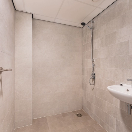 An unfurnished restroom with a sink and shower, ideal for office space rental at Walborg 2A, Amsterdam Buitenveldert.