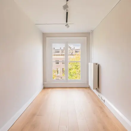 Bright office to rent at Herengracht 582-584, Amsterdam Canal Belt, with large window and wooden floor, ideal for office space rental.