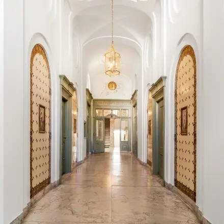 Elegant entrance hallway with classic arches, ornate chandeliers, and vintage decor details at Keizersgracht 261 in Amsterdam Canal Belt, ideal for office space rental.