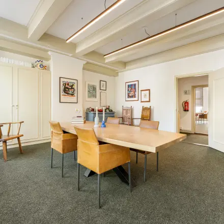 Furnished office space for rent at Keizersgracht 261, Amsterdam Canal Belt, featuring a spacious meeting area with a large wooden table and chairs, ideal for office space rental.