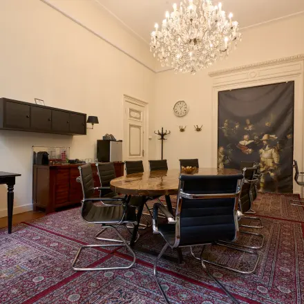 Elegant office space rental in Amsterdam Canal Belt, featuring a grand chandelier and classic furnishings at Keizersgracht 391A.