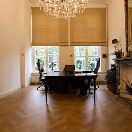Bright office space with large windows, elegant chandelier, and classic fireplace at Keizersgracht 391A, Amsterdam Canal Belt. Ideal for office space rental with potential for stylish work environment.