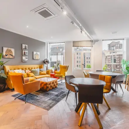 Bright and stylish office interior at Hekelveld 8-10 in Amsterdam Center, featuring chic furnishings and large windows for rent office space.