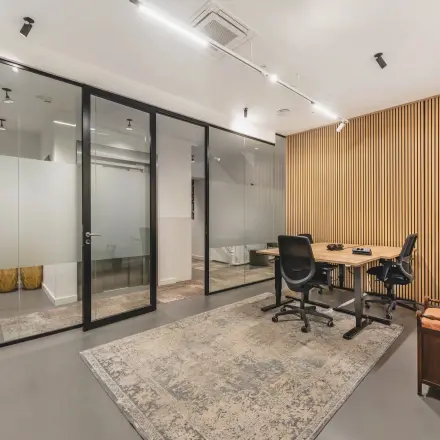Modern office space available for rent at Hekelveld 8-10, Amsterdam Center, featuring sleek glass partitions and comfortable furnishings.