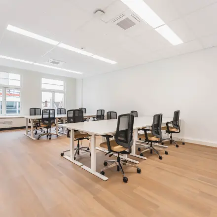 Bright office space with several desks and chairs arranged for workspace rental at Herengracht 471, Amsterdam Center.