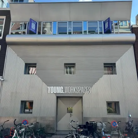 Exterior view of an office building for rent at Kerkstraat 204, Amsterdam Center, featuring a modern facade and bicycles parked outside.