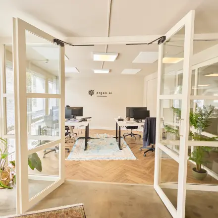 Bright office space at Kleine Gartmanplantsoen 21, Amsterdam Center, featuring glass doors and modern furnishings. Ideal for office space rental with plants enhancing the workspace ambiance.
