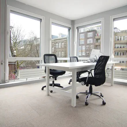 Bright, furnished office space for rent with large windows and modern desks at Kleine Gartmanplantsoen 21, Amsterdam Center.