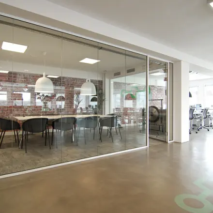 Modern office space at Kleine Gartmanplantsoen 21 in Amsterdam Center featuring glass-walled conference room and open workspaces, perfect for office space rental.