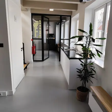 Modern office space at Kloveniersburgwal 131K, Amsterdam Center, featuring sleek decor with large windows and potted plants, suitable for office space rental.