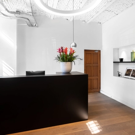 Modern office reception with a sleek black desk at Nieuwezijds Voorburgwal 104-108 in Amsterdam Center, ideal for office space rental.