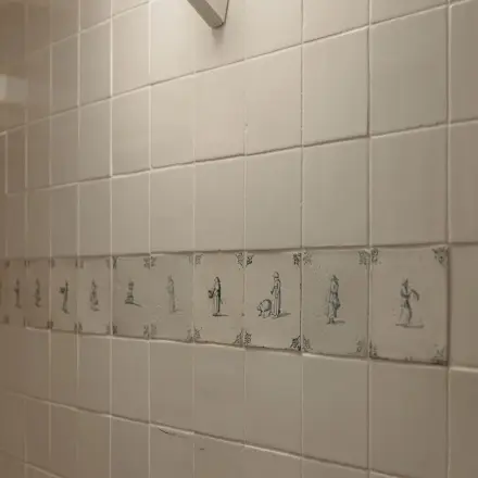 Tiled wall with decorative illustrations at Prins Hendrikkade 14, Amsterdam Center. Ideal for office space rental.