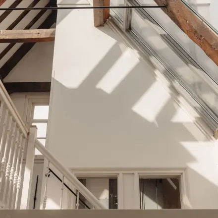 Bright office space with wooden beams and large windows at Prins Hendrikkade 14, an ideal location for office space rental in Amsterdam Center.