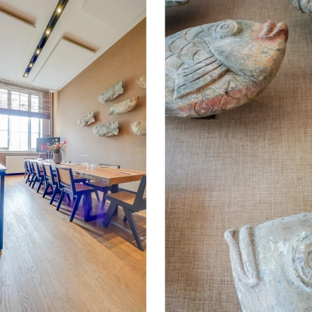 Rent office space at Raamplein 1, Amsterdam Center featuring a furnished, long meeting table with chairs and decorative wall art.