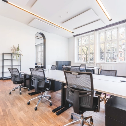 Spacious office space at Raamplein 1, Amsterdam Center, featuring sleek desks and chairs in a bright, modern setting, perfect for office space rental.