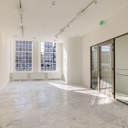 Bright office space at Rokin 117, Amsterdam Center, featuring marble floors and large windows ideal for office space rental.