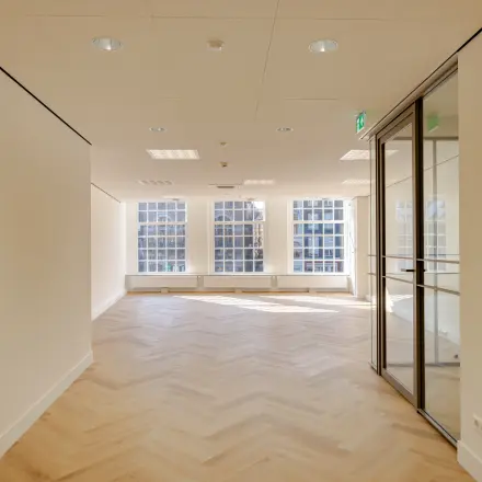 Spacious office space rental at Rokin 117, 117 in Amsterdam Center with large windows and wooden floors. Ideal for businesses seeking an office to rent.