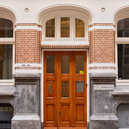 Elegant exterior view of an office building entrance at Warmoesstraat 149-151, perfect for those seeking office space rental in Amsterdam Center.