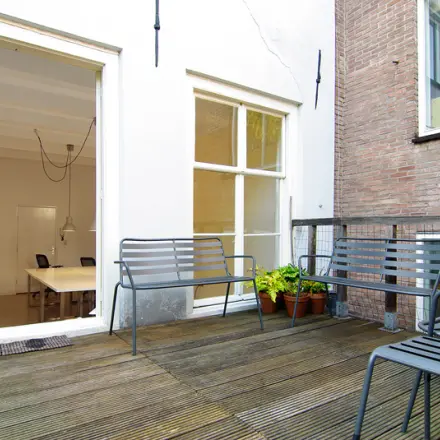 Outdoor seating area at an office to rent on Warmoesstraat 155, Amsterdam Center, with beyond view of an interior workspace.