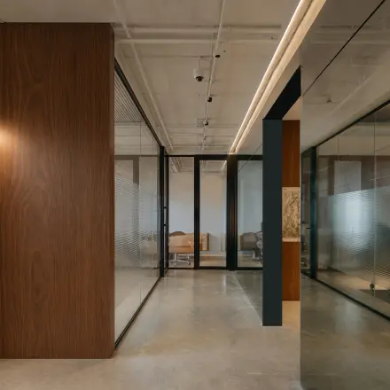 Modern office interior with wooden finishes and glass partitions at Weteringschans 26, ideal for office space rental in Amsterdam Center.