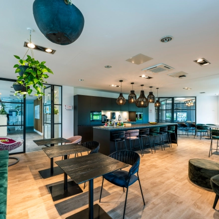 Inviting office space at Overschiestraat 186, Amsterdam De Schinkel, featuring well-furnished workspaces with modern seating and ambient lighting, perfect for office space rental needs.