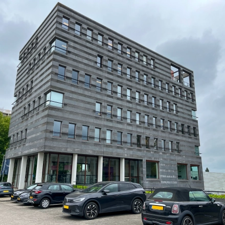 Exterior view of the office building at Daalwijkdreef 47, Amsterdam Duivendrecht, featuring multiple floors and parking area, ideal for office space rental.