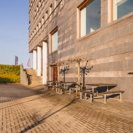 Exterior of Daalwijkdreef 47 in Amsterdam Duivendrecht featuring modern architecture and outdoor seating, ideal for an office space rental.