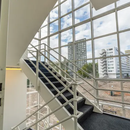 Staircase with large windows offering views of the surrounding Amsterdam East skyline at James Wattstraat 71.
