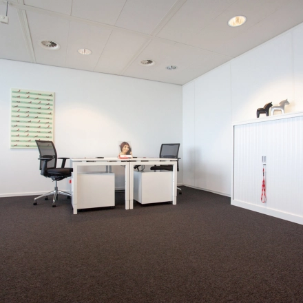 Bright office space at Piet Heinkade 55, Amsterdam East, featuring modern furnishings and minimal decor, available for office space rental.
