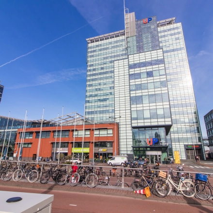 Exterior view of an office building at Piet Heinkade 55, Amsterdam East, featuring a modern glass facade. Ideal for those seeking office space rental in a prime location.