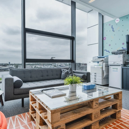 Bright office space at Piet Heinkade 95B in Amsterdam East with modern decor, featuring a comfortable seating area and a view of the city. Ideal for office space rental opportunities.