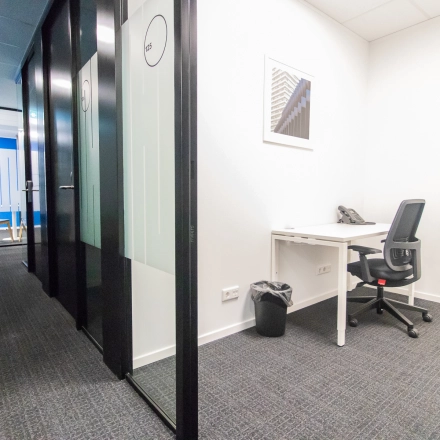 Modern office space with a desk, chair, and phone, located at Rhijnspoorplein 10-38, Amsterdam East. Suitable for those looking for office space rental.