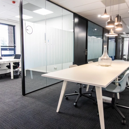 Bright, modern office space at Rhijnspoorplein 10-38 in Amsterdam East featuring sleek desks and contemporary lighting, ideal for office space rental.