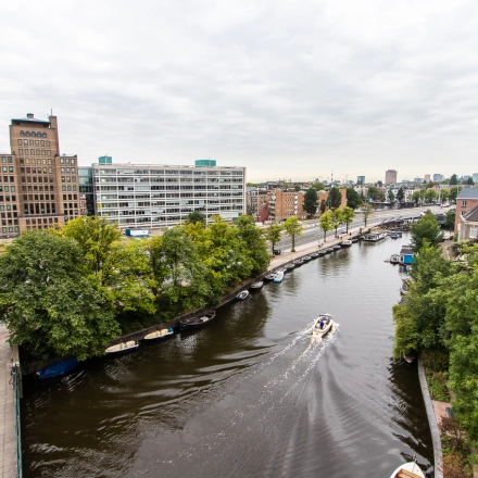 View of Rhijnspoorplein 10-38 in Amsterdam East, showcasing nearby waterways and urban surroundings, ideal for office space rental.