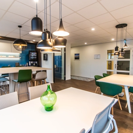 Modern office space at Rhijnspoorplein 10-38 in Amsterdam East with stylish furnishings, perfect for office space rental. Features sleek tables and contemporary lighting.