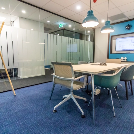 Modern conference room with a large table, ergonomic chairs, and glass partitions in an office available for rent at Rhijnspoorplein 10-38, Amsterdam East.