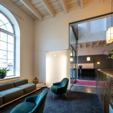 Spacious office lobby at Sarphatistraat 370, Amsterdam East, featuring modern seating and bright lighting, ideal for office space rental.