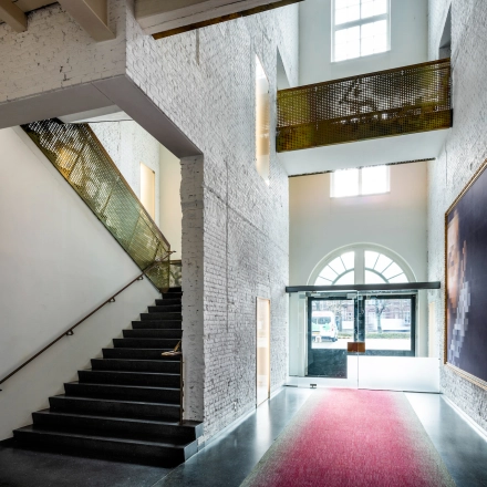 Entrance area at Sarphatistraat 370, Amsterdam East, featuring unique architecture and striking artwork - perfect for rent office space seekers.