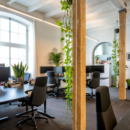 Bright office space in Amsterdam East with multiple desks, plants, and monitors, ideal for rent office space or office space rental.
