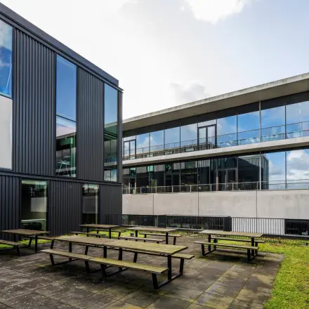 Modern office exterior with large windows and communal outdoor space at Moermanskkade 109-113, perfect for office space rental in Amsterdam Houthavens.