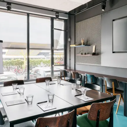 Bright and modern workspace at Jan van Galenstraat 335, Amsterdam New-West, available for office space rental, featuring large windows and a conference setup.