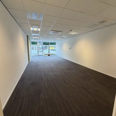 Spacious interior of an unfurnished office to rent at Buikslotermeerplein 430, Amsterdam North, with bright lighting and large windows at the far end.