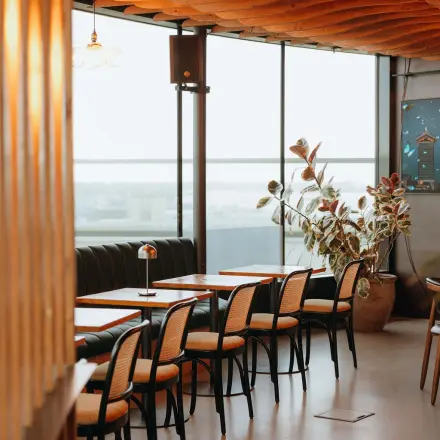 Furnished office space with tables and chairs near large windows at Overhoeksplein 1, ideal for rent office space needs.
